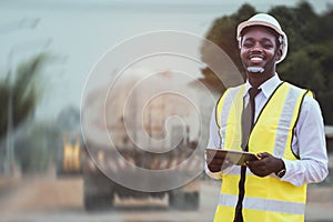 African civil engineering working with use tablet for control the road rebuilding and inspect the construction site with roller