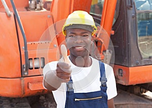 African construction worker with red excavator showing thumb