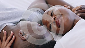 African couple in communication on bed, happy with conversation in bedroom and talking funny on love date in marriage in