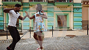 African couple dancing jive in city. Sexy afro dancers making footwork on street