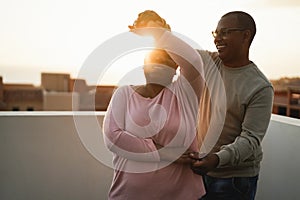 African couple dancing outdoors at summer sunset - Focus on man face