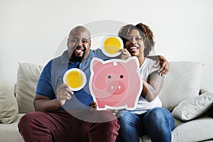 An African couple holding saving money icons home family saving investment concept