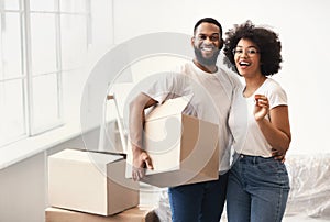 African Couple Posing With Moving Boxes And House Key Indoors