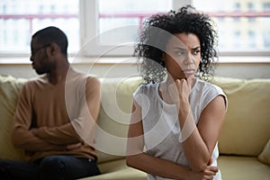 African couple sitting apart thinking about relations problems