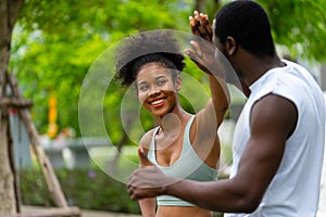 African couple in sportware touching hands together smiling with happy in the park