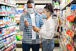 African Couple Using Smartphone Scanning Food Product In Supermarket