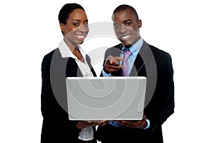 African coworkers operating laptop and pointing