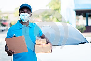 African delivery man holding boxs and cardboard with wearing face mask