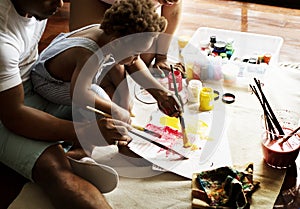 African descent dad teaching his child how to paint