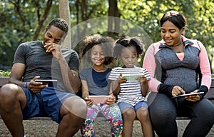 African Descent Family together sitting on a bench in the park