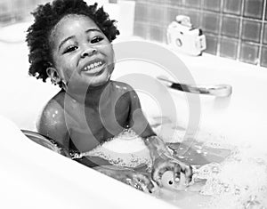 African descent kid enjoying bath tub photo