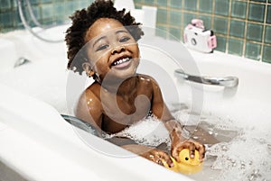 African descent kid enjoying bath tub photo