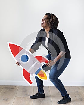 African descent woman holding rocketship icon