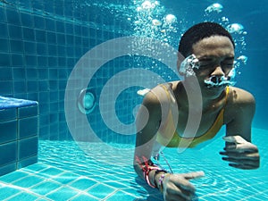 African descent woman underwater in swimming pool