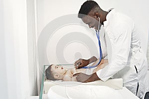 African doctor examines a little boy on couch