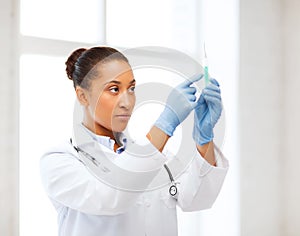 African doctor holding syringe with injection