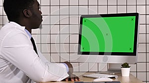 African doctor making video call with his computer. White display.