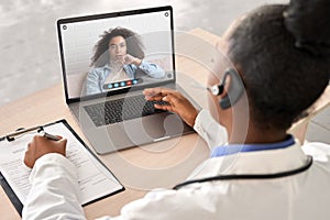 African doctor talk to patient by online webcam video call on laptop screen. photo