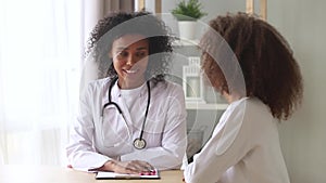 African doctor and teen girl having confidential conversation