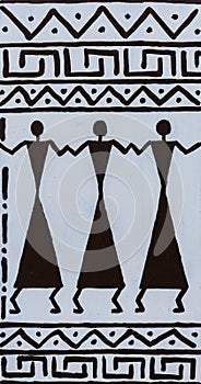 African drawing on a white wall with ornaments and figures of people, closeup