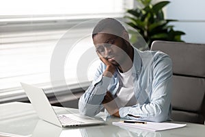 African employee falls asleep seated on chair at workplace