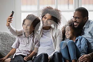 African ethnicity family with children taking selfie picture using smartphone