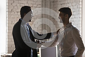 African executive manager handshaking caucasian employee promoti