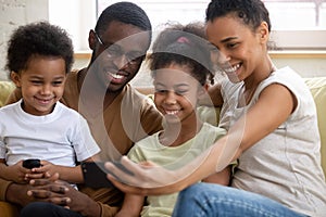 African family with kids watching funny videos on smartphone
