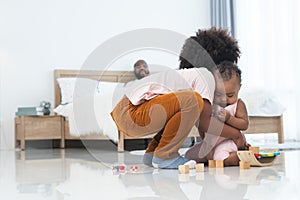 African family, little boy holding cute newborn baby girl, brother and sister playing wooden blocks toy and xylophone together on