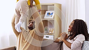 African family playing with baby daughter at home