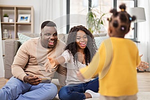 African family playing with baby daughter at home