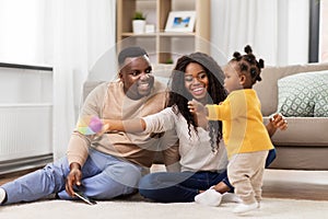 African family playing with baby daughter at home