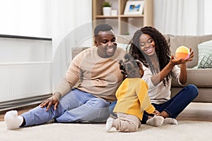 African family playing with baby daughter at home