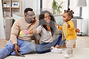 African family playing with baby daughter at home