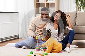 African family playing with baby daughter at home