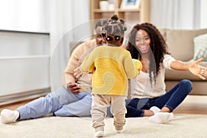 African family playing with baby daughter at home