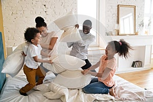 African family spend time in bedroom fighting with pillows photo