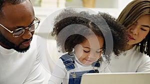 African family teaching their children to use a laptop.