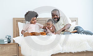 African family, 5 years boy, cute 11 months toddler baby girl and father have fun playing car model toy and reading book together