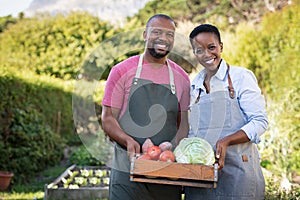 African farmer couple holding vegetable crate photo