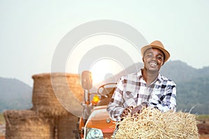 African farmer stand in front of tractor and haystack.Agriculture or cultivation concept