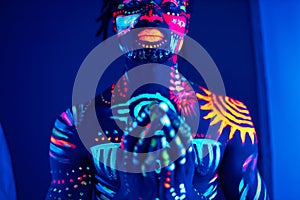 African fashion model with fluorescent make-up and body art