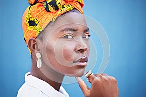 African, fashion and portrait of black woman on blue background with head scarf, glowing skin and makeup. Beauty