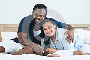 African father and Asian mother touching and lull cute newborn baby sleeping lying on bed at home, parent smiling looking at