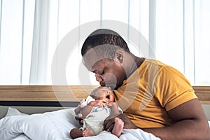 African father Blow air on his 12-day-old black skin baby newborn son`s forehead to convince him to sleep
