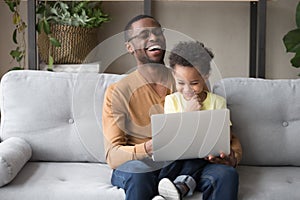 African father and cute kid son having fun with computer