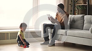 African father and kid son spend time in living room