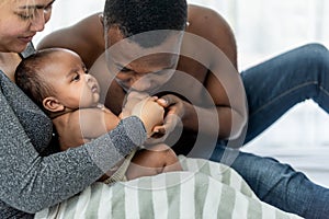 African father kissing hand, his 3-mount-old baby newborn daughter