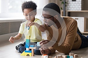 African father and son play with colourful toy blocks