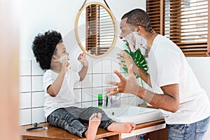 African Father and son playing shaving foam